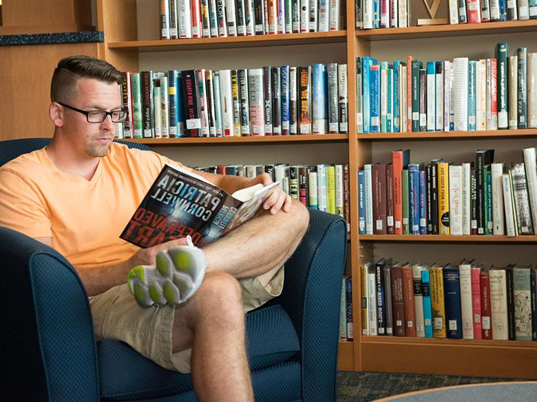 student reading a book in the library